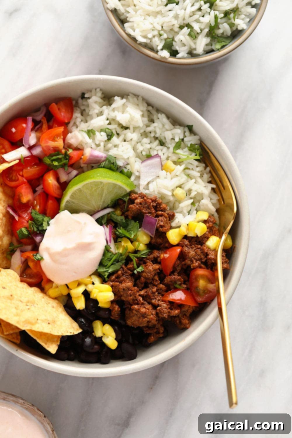 Whip up this filling beef taco bowl recipe for an incredible meal prep idea that's perfect for a work lunch or dinner at home! A perfectly assembled taco bowl featuring ground beef and vibrant cilantro lime brown rice.