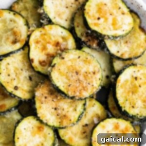 Crispy Parmesan Zucchini Bites 7 Crispy zucchini rounds coated in Parmesan on a plate, ready to eat.