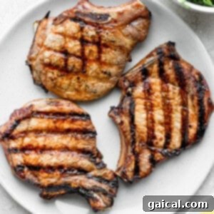 Grilled pork chops served on a plate with garnishes