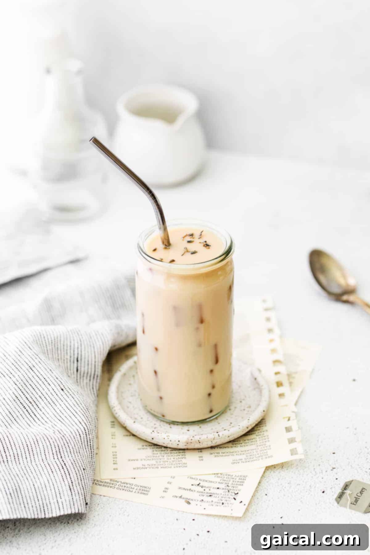 Refreshing Iced London Fog Latte with Earl Grey Tea and Milk A refreshing Iced London Fog Latte in a tall glass with ice and a straw.