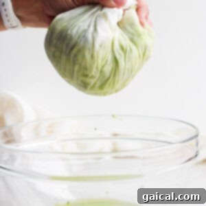 Hands squeezing moisture out of shredded zucchini.