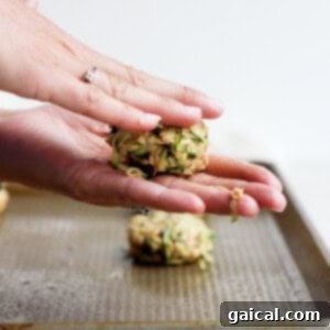 Hands forming cookie dough into cookies.