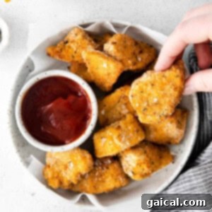 chicken nuggets in a bowl with ketchup.