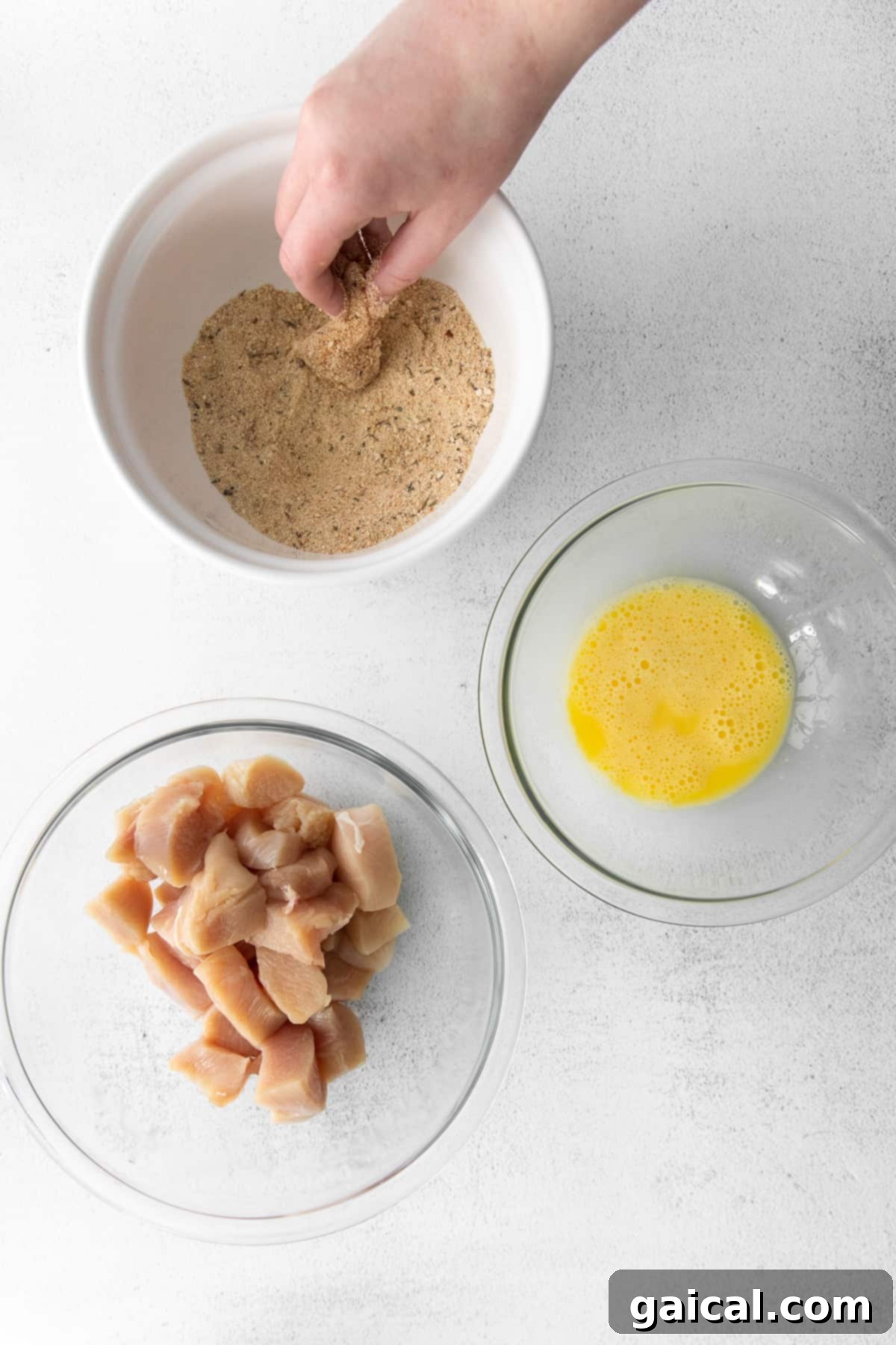Perfectly Crispy Air Fryer Nuggets 4 Dipping chicken in bread crumbs.