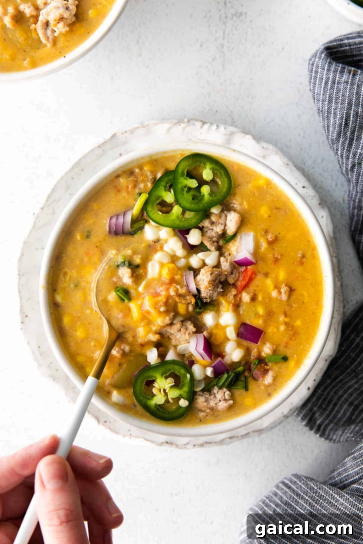 The Best Homemade Sweet Corn Chowder A steaming bowl of homemade sweet corn chowder, garnished with fresh herbs and a sprinkle of ground pork.