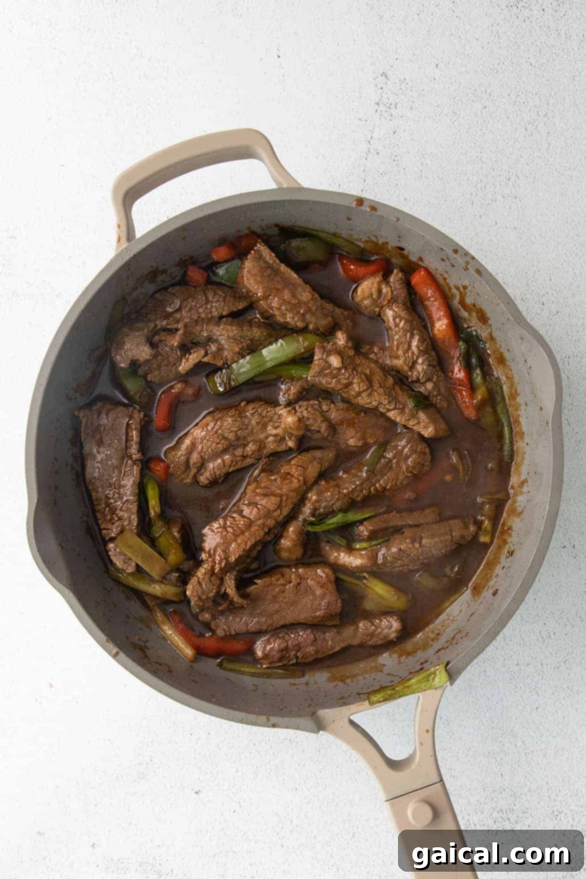Sizzling Pepper Steak 7 Pepper steak cooking in a fry pan.