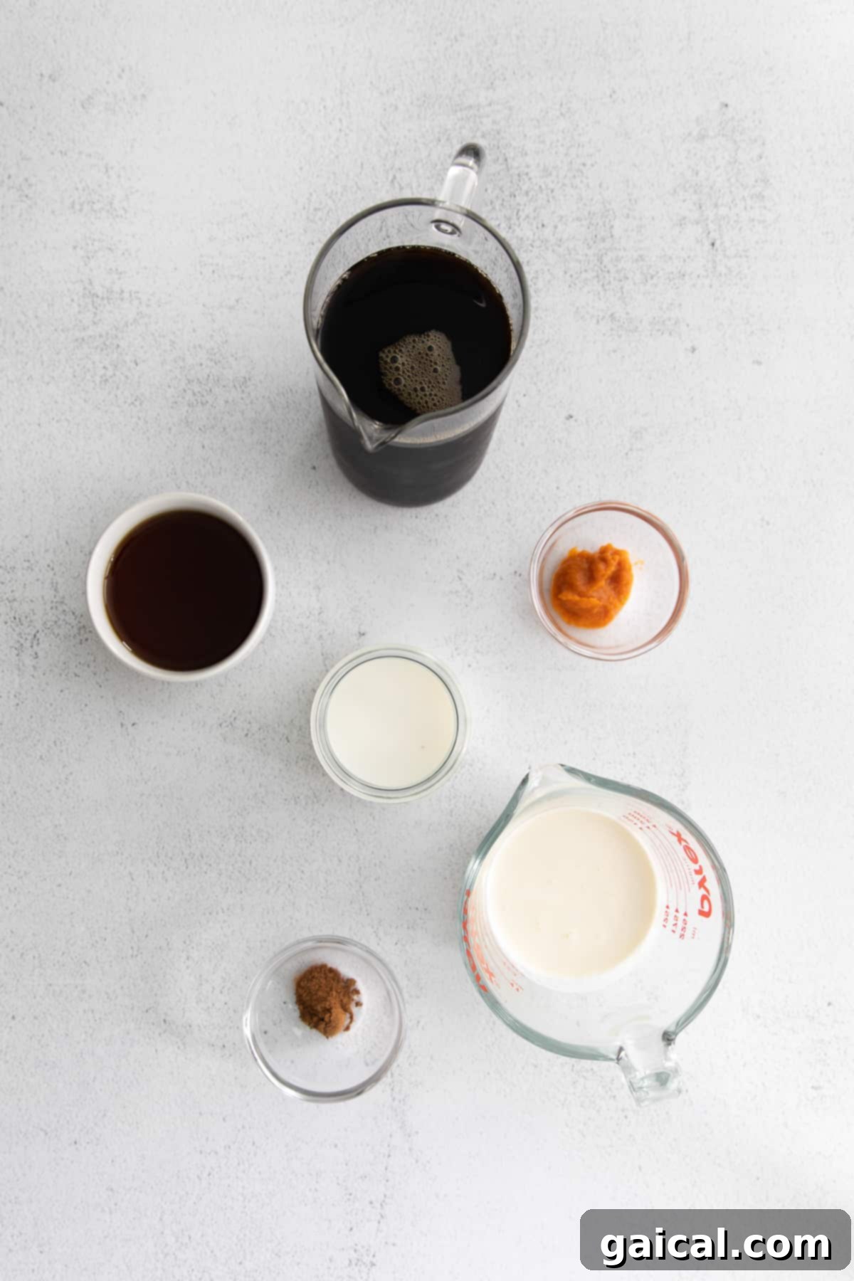 Individual ingredients for Pumpkin Cream Cold Brew laid out in small bowls and jars.