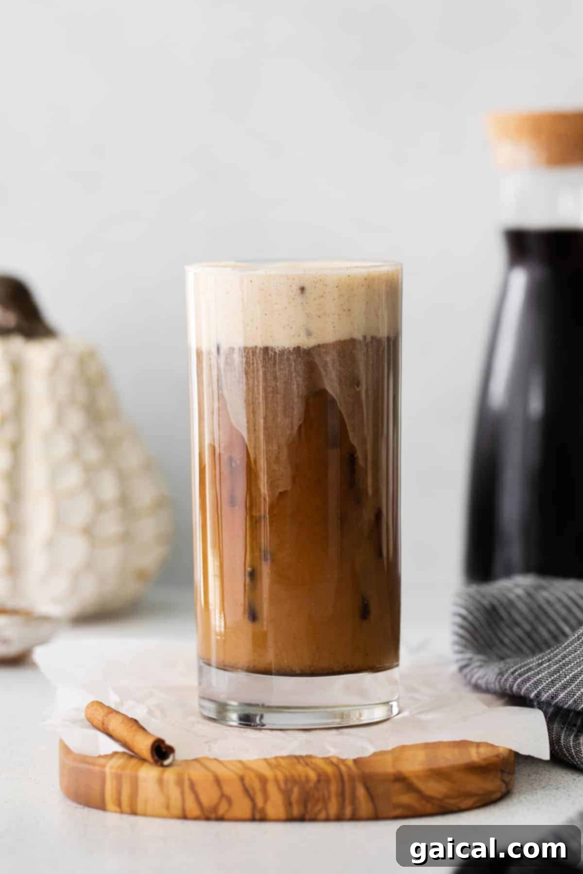A beautifully layered Pumpkin Cream Cold Brew in a glass, poured over ice.