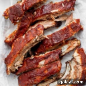 A close-up of beautifully sliced, saucy oven baked ribs.