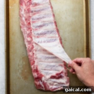 Removing the membrane from the ribs for a more tender result.