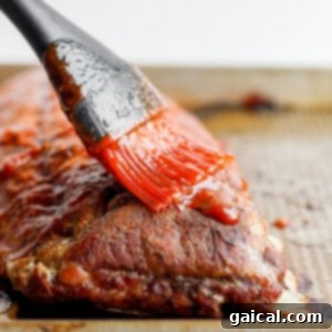 Slathering delicious homemade BBQ sauce onto the tender ribs.
