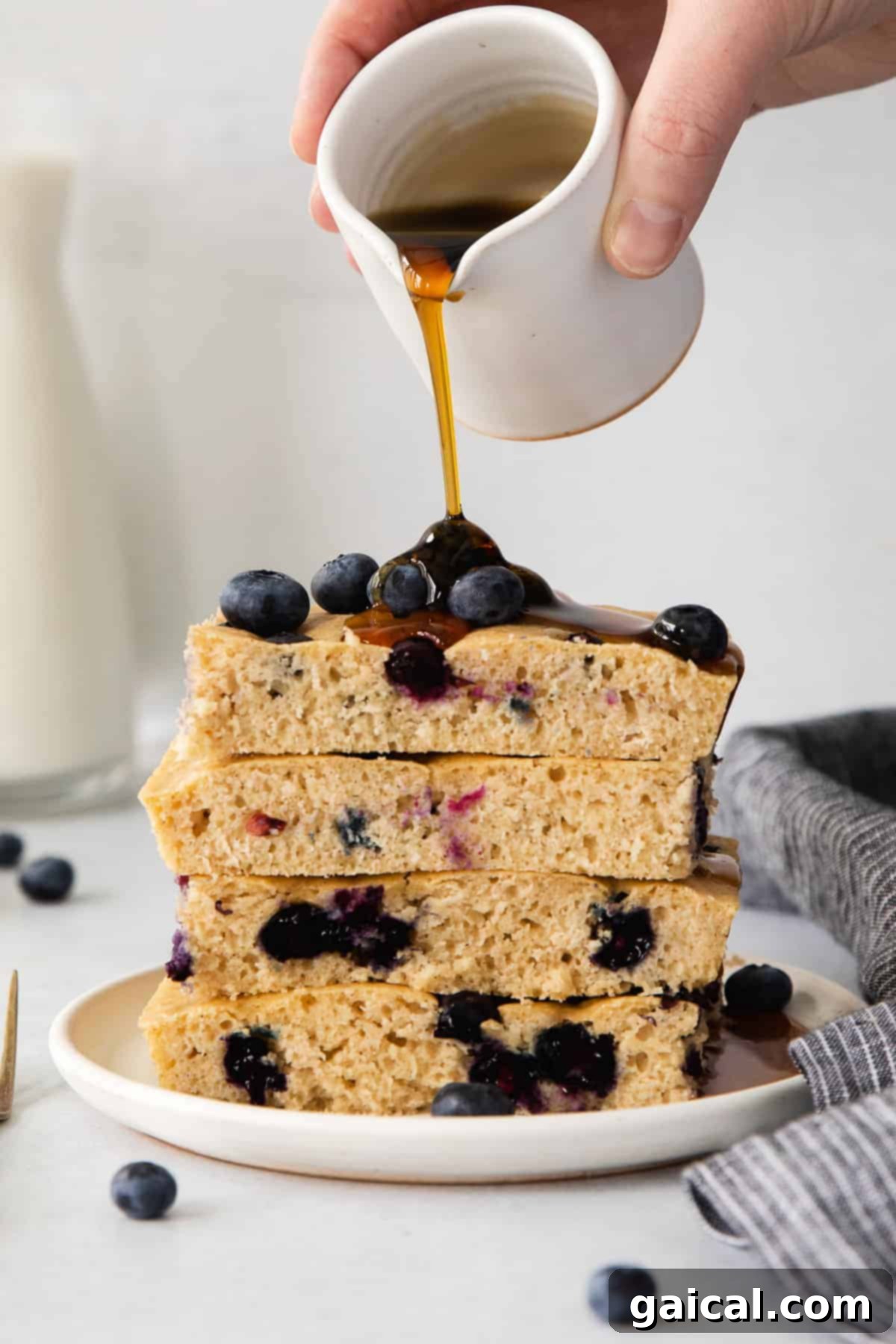 Easy Sheet Pan Pancakes with Syrup and Berries Golden-brown sheet pan pancakes drizzled with maple syrup and fresh berries, ready to be served for a family breakfast.