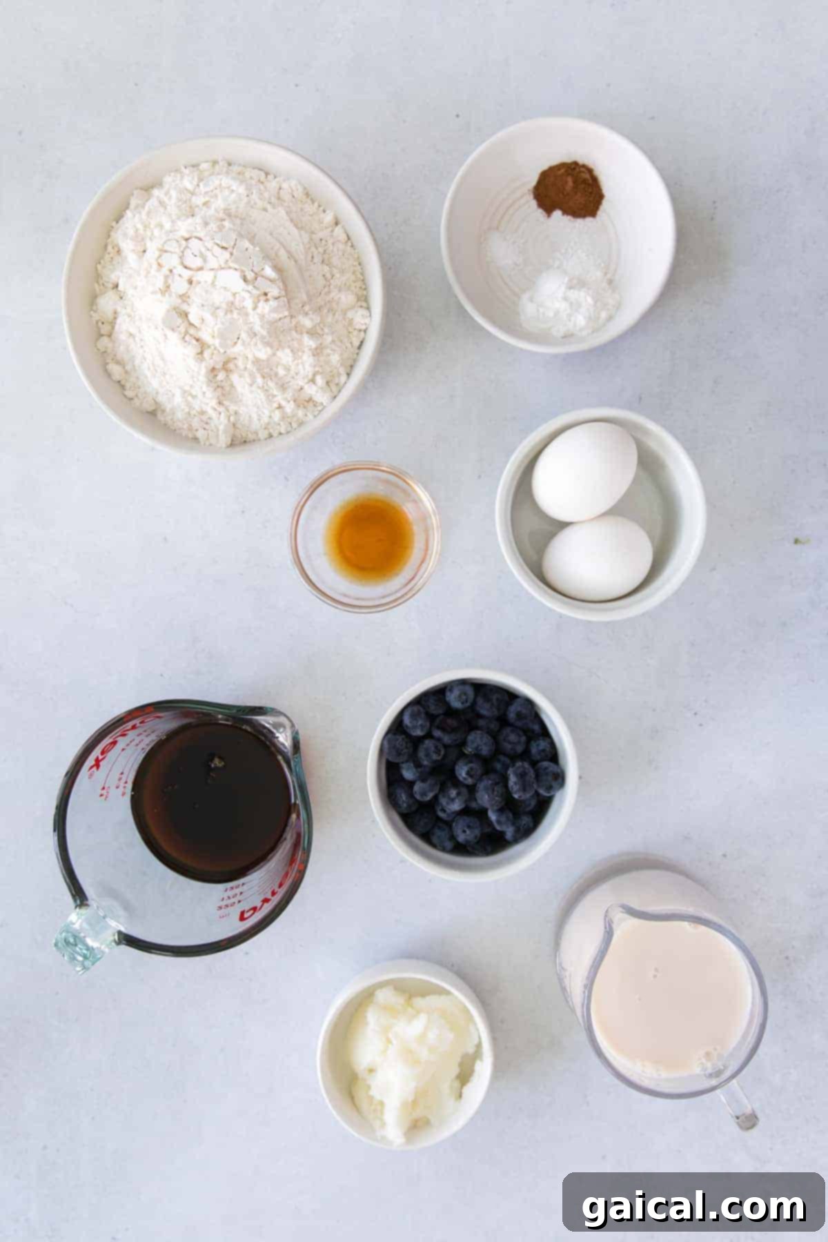 Sheet Pan Pancake Ingredients Fresh ingredients laid out on a kitchen counter, including flour, baking powder, blueberries, eggs, and milk, ready for making sheet pan pancakes.