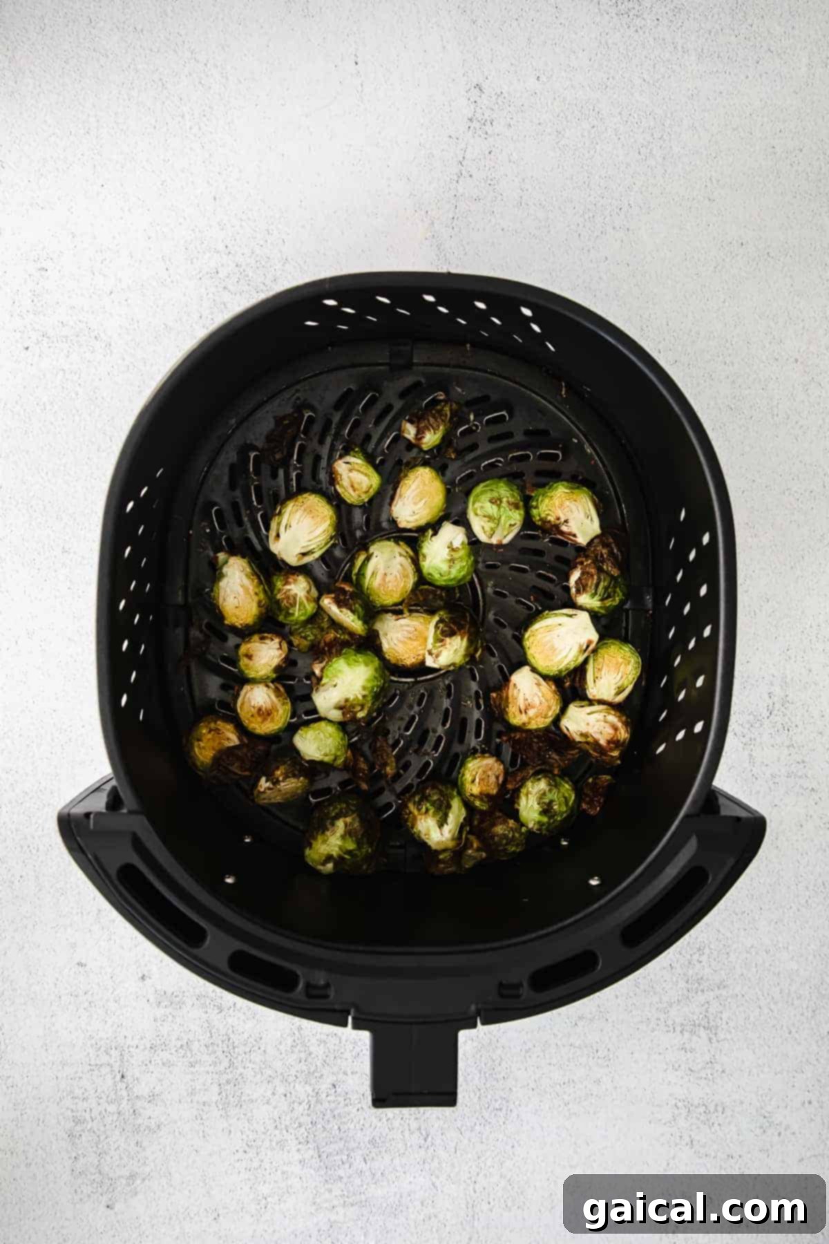 Perfectly Crisp Air-Fried Brussels 5 Brussel sprouts in an air fryer.