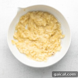 Mashed banana in a bowl, prepared for the wet ingredients.