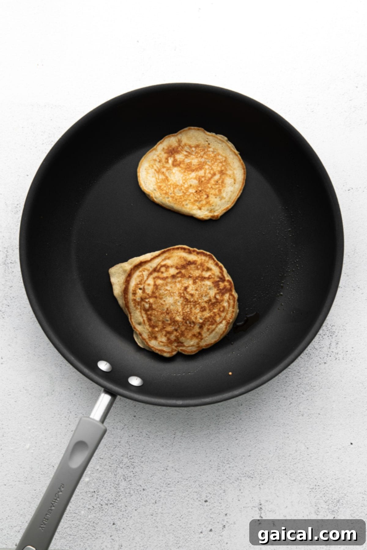 Nourishing Banana Pancakes 6 Banana pancakes sizzling on a hot nonstick griddle, turning golden brown.