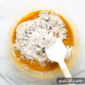 Marbled Brown Sugar Pumpkin Breakfast Cake 9 A bowl filled with flour and a wooden spatula.