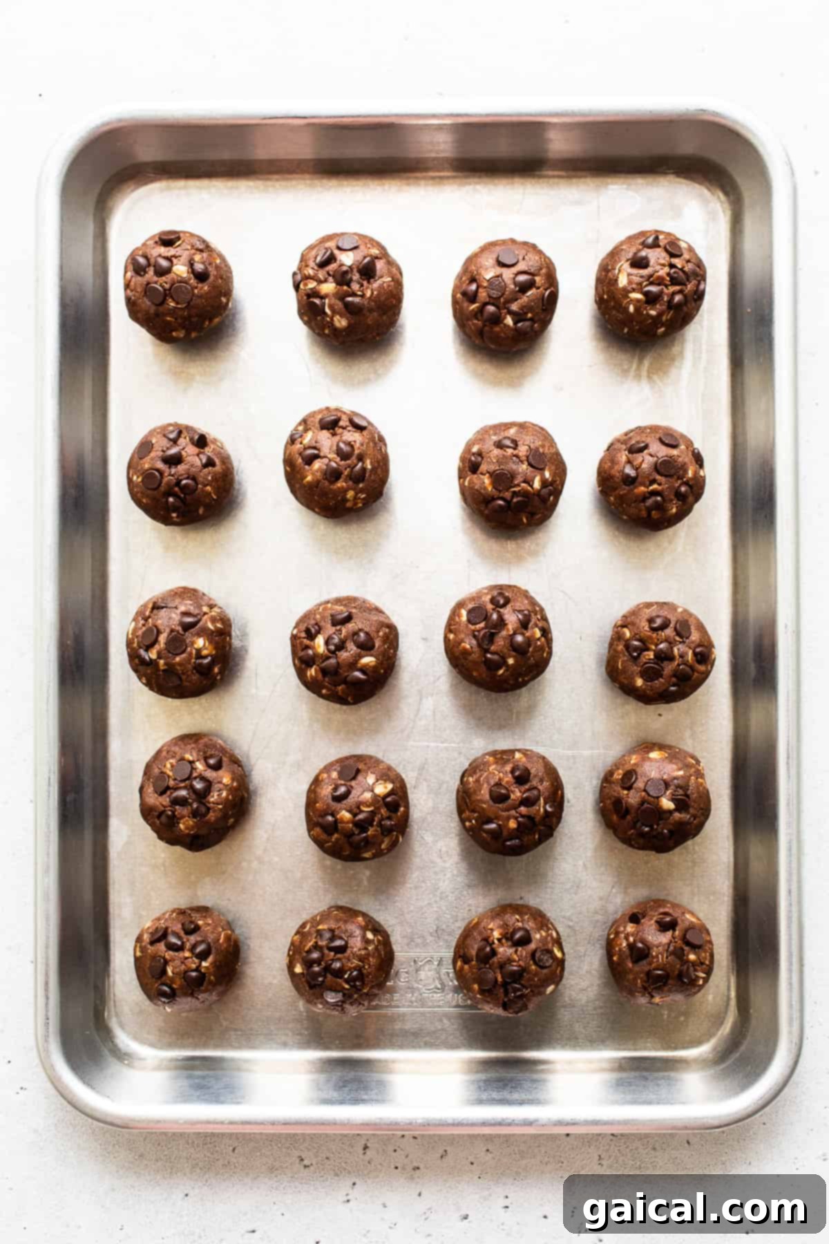 Mint Chip Protein Balls Ready to Chill Freshly rolled mint chip protein balls cooling on a baking sheet lined with parchment paper, ready for chilling to firm up.