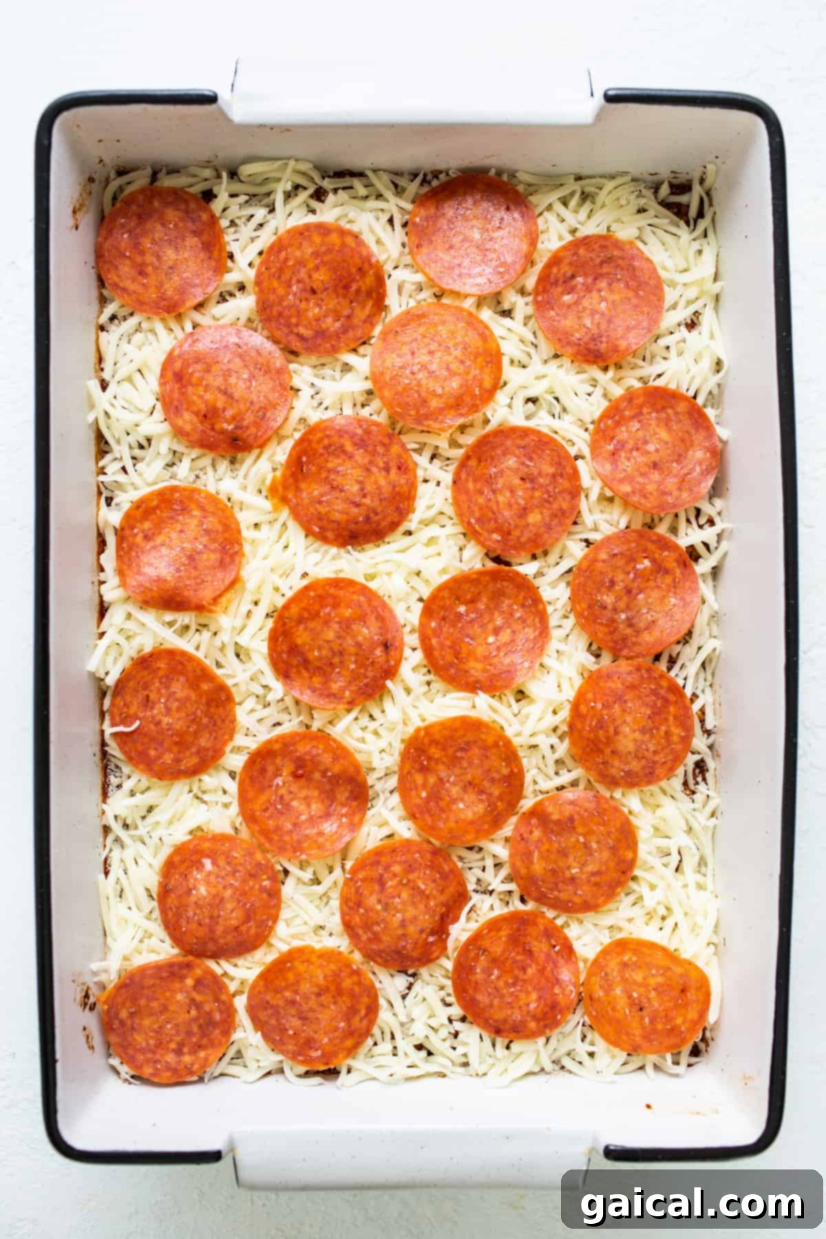 Wholesome Quinoa Pizza Bake 5 A baked pepperoni pizza quinoa casserole, glistening with melted cheese, inside a rustic baking dish.