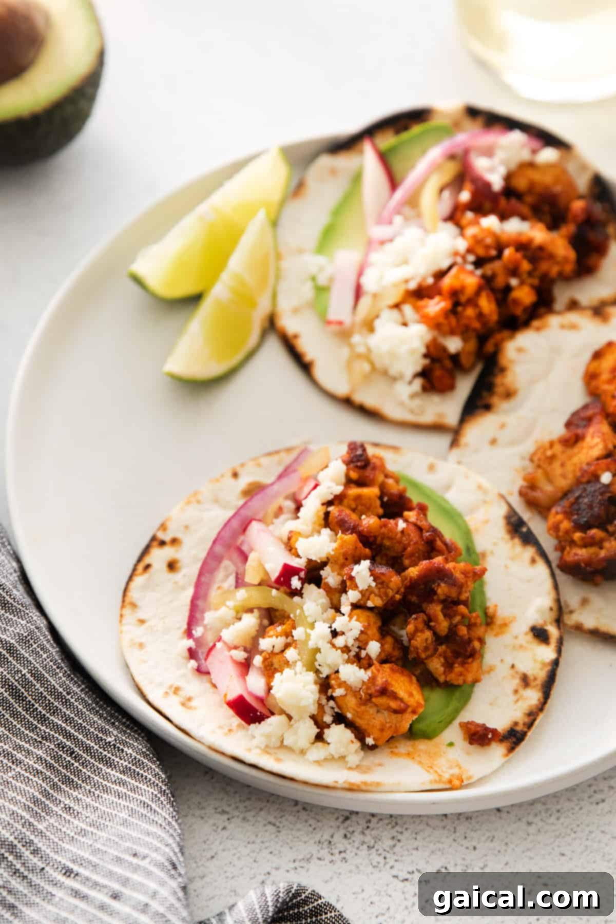 Beautifully assembled tofu tacos with radish slaw and avocado slices, ready to eat.