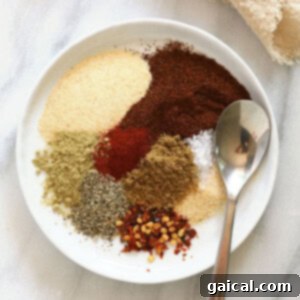 A bowl of rich, reddish-brown homemade taco seasoning with various spices.