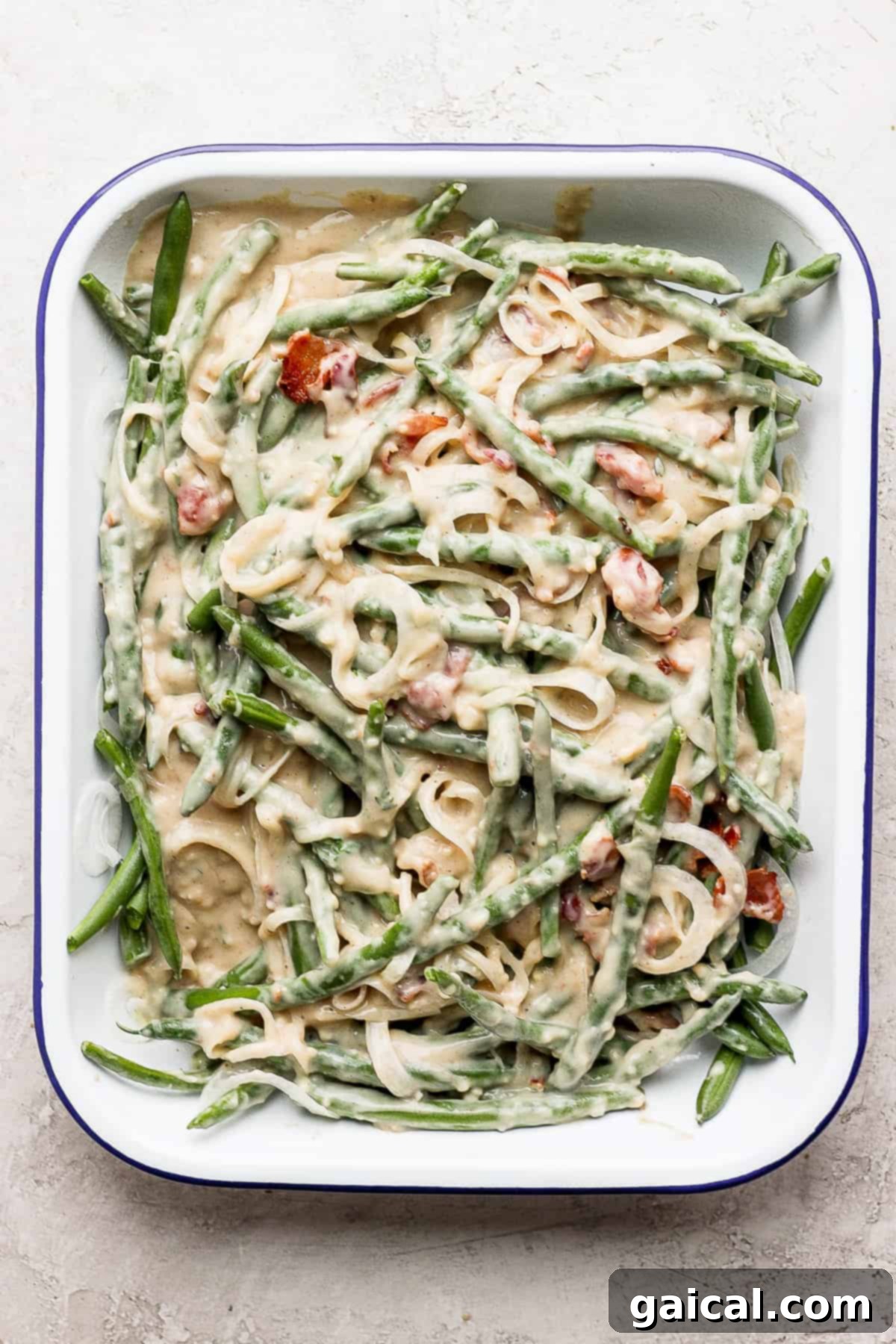 This green bean casserole with bacon is a homemade version of a classic recipe, but instead of using a cream of mushroom soup it features an amazing bacon roux. green bean casserole with bacon mixed together