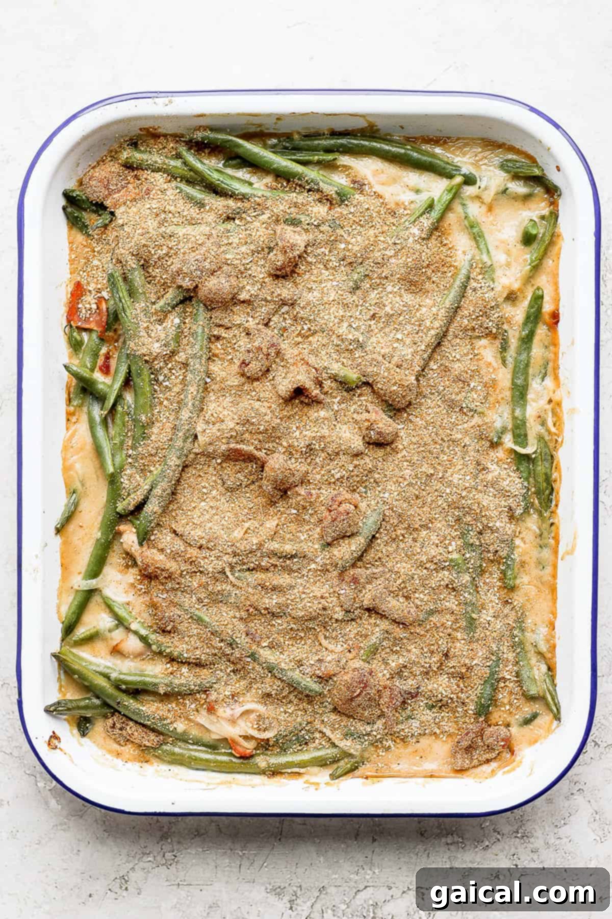This green bean casserole with bacon is a homemade version of a classic recipe, but instead of using a cream of mushroom soup it features an amazing bacon roux. green bean casserole with bacon and a breadcrumb topping, ready to go in the oven