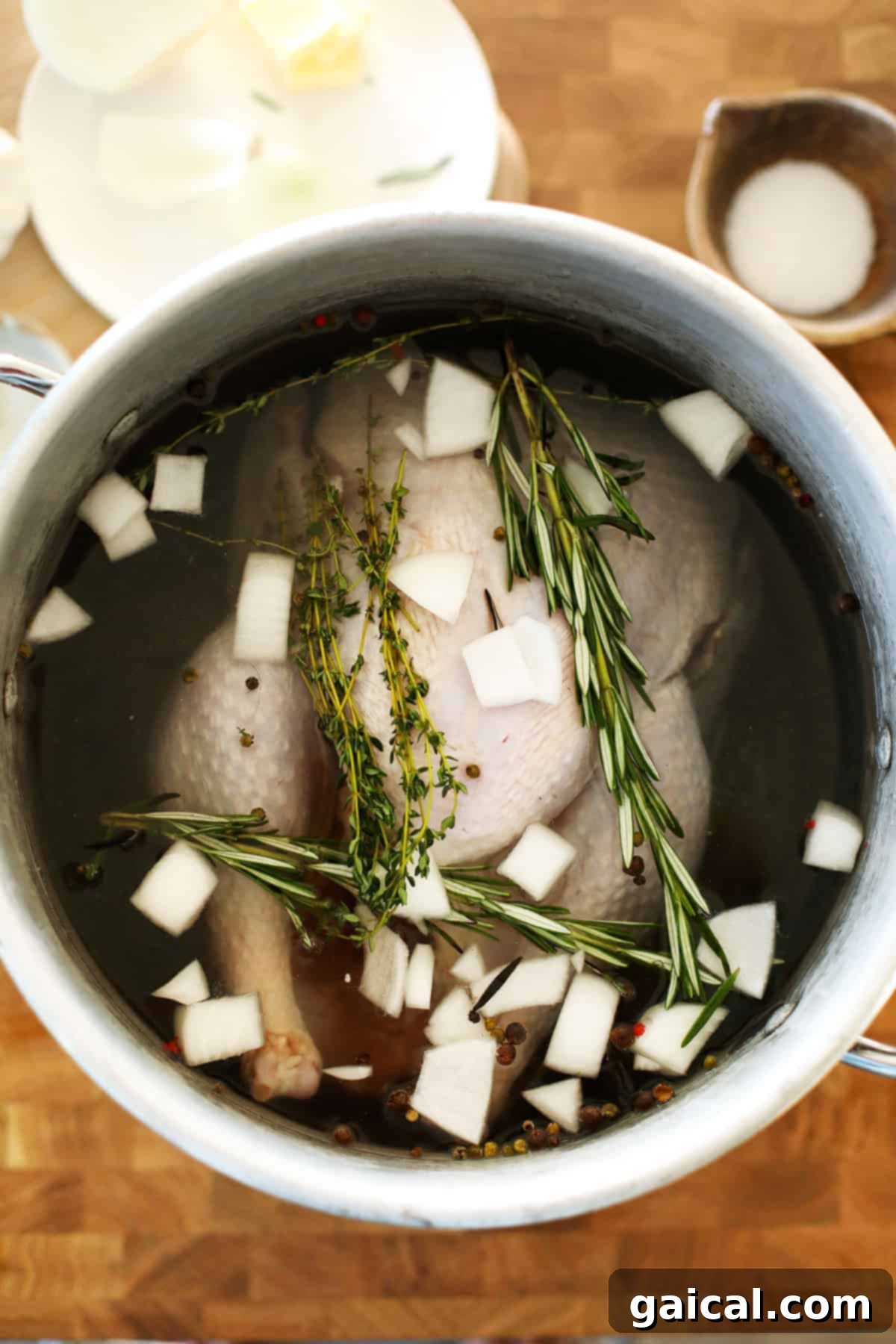 Ultimate Smoked Turkey Brine 2 A large pot containing a turkey submerged in a clear brine solution, signifying the brining process in progress.