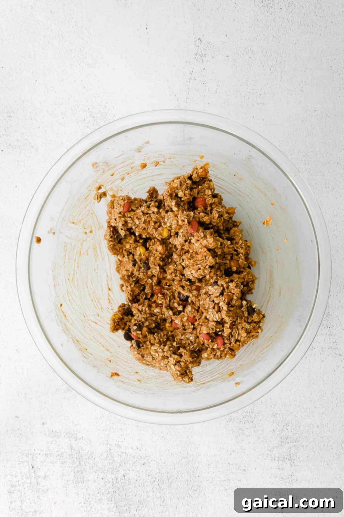 The most delicious fall cookies you've ever tasted - Pumpkin Monster Cookies made with pumpkin puree, butterscotch chips, and m&m's. cookie dough in a mixing bowl, ready for baking