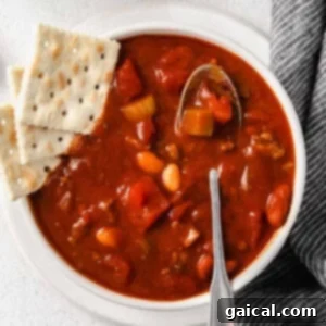chili in bowl with crackers and a spoon.