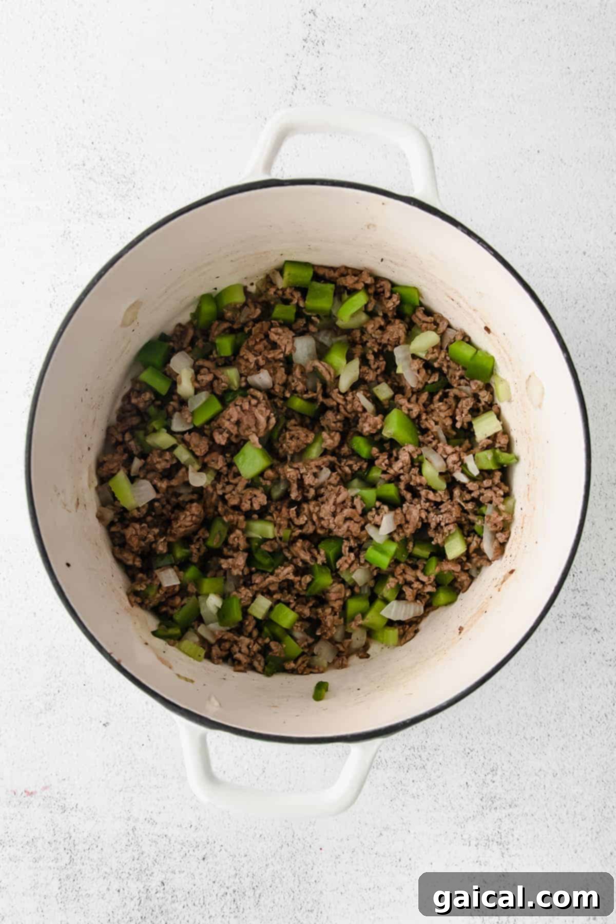 Ground beef browning in a large Dutch oven, preparing for the chili base.