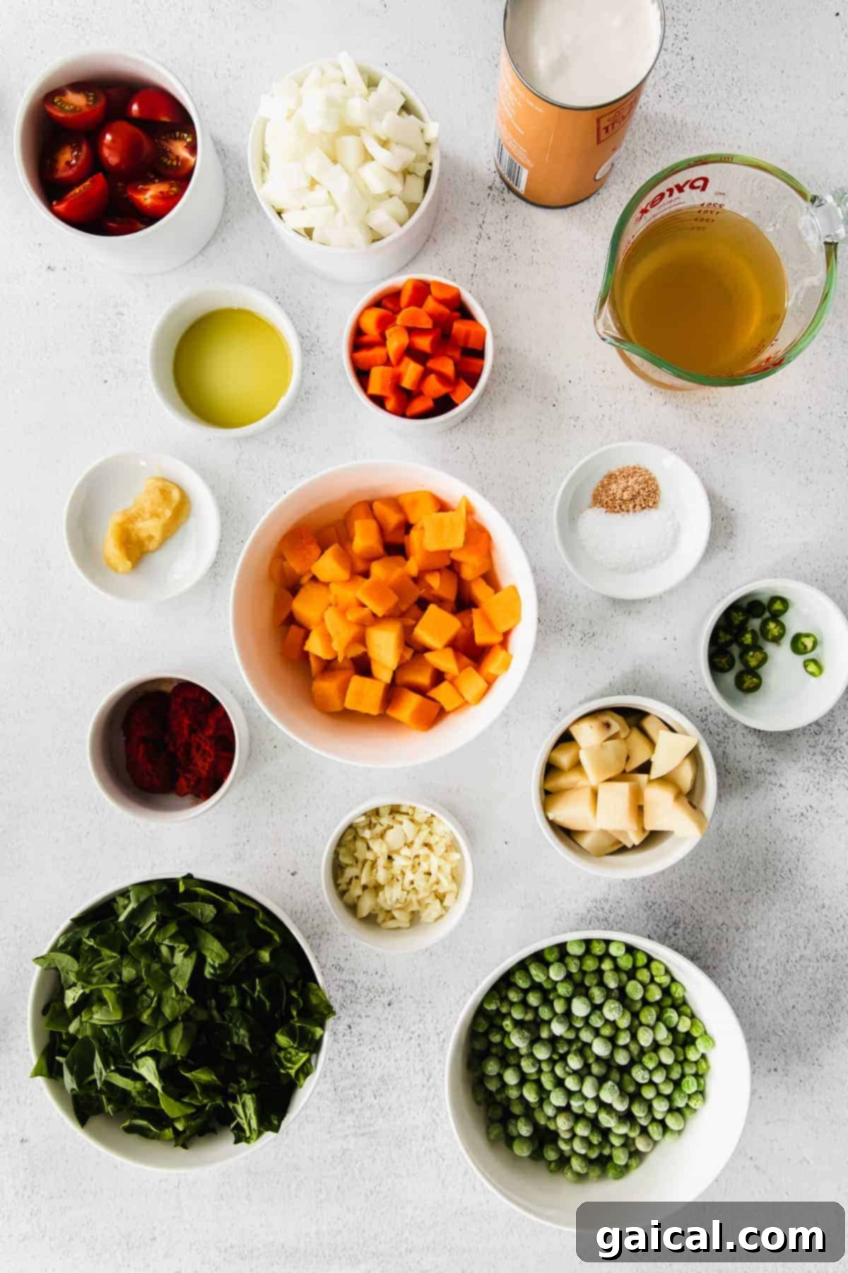 Flavorful Instant Pot Pumpkin Curry 3 Assortment of fresh ingredients laid out on a kitchen counter, including pumpkin, onions, garlic, ginger, and various spices, ready for making curry.