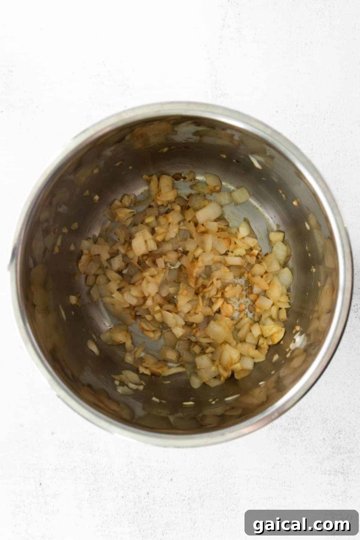Flavorful Instant Pot Pumpkin Curry 4 Onions and garlic being sautéed in an Instant Pot, forming the aromatic base for the creamy pumpkin curry.