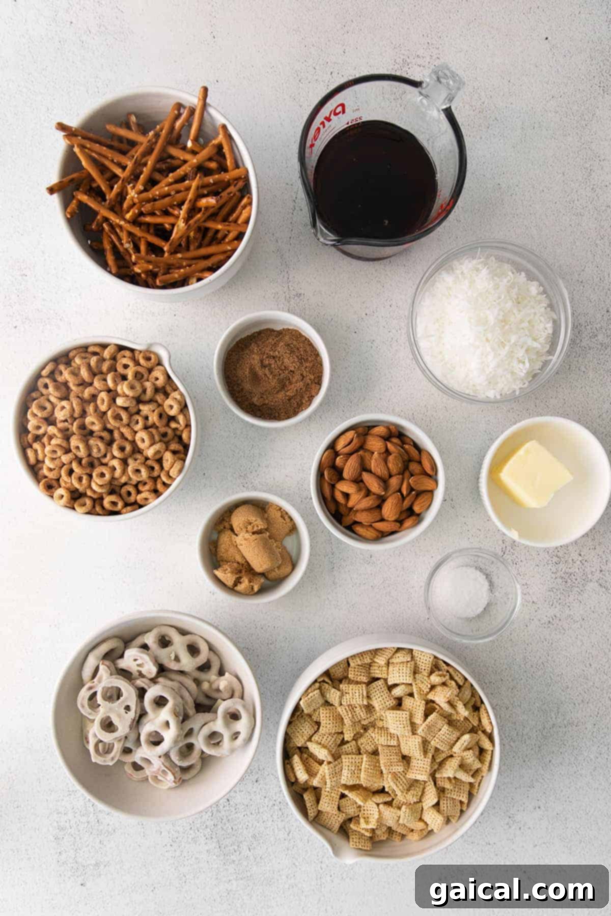 Maple Chai Chex Crunch 3 All the dry ingredients for Chai Chex Mix, including cereals, nuts, and pretzels, laid out on a clean kitchen counter, ready to be combined.