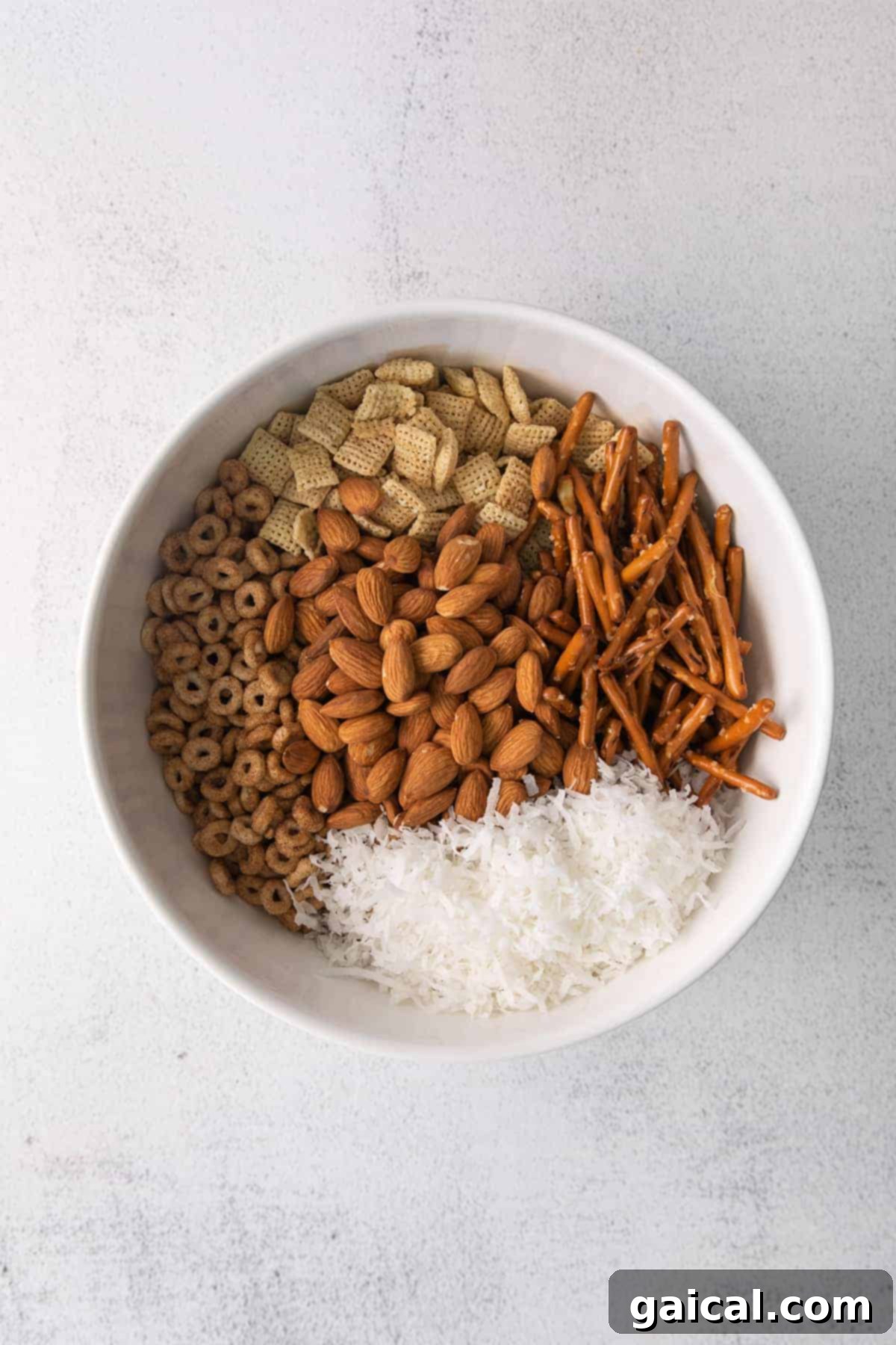 Maple Chai Chex Crunch 4 All the dry ingredients for Chai Chex Mix, including various cereals, nuts, and pretzels, neatly combined in a large mixing bowl.