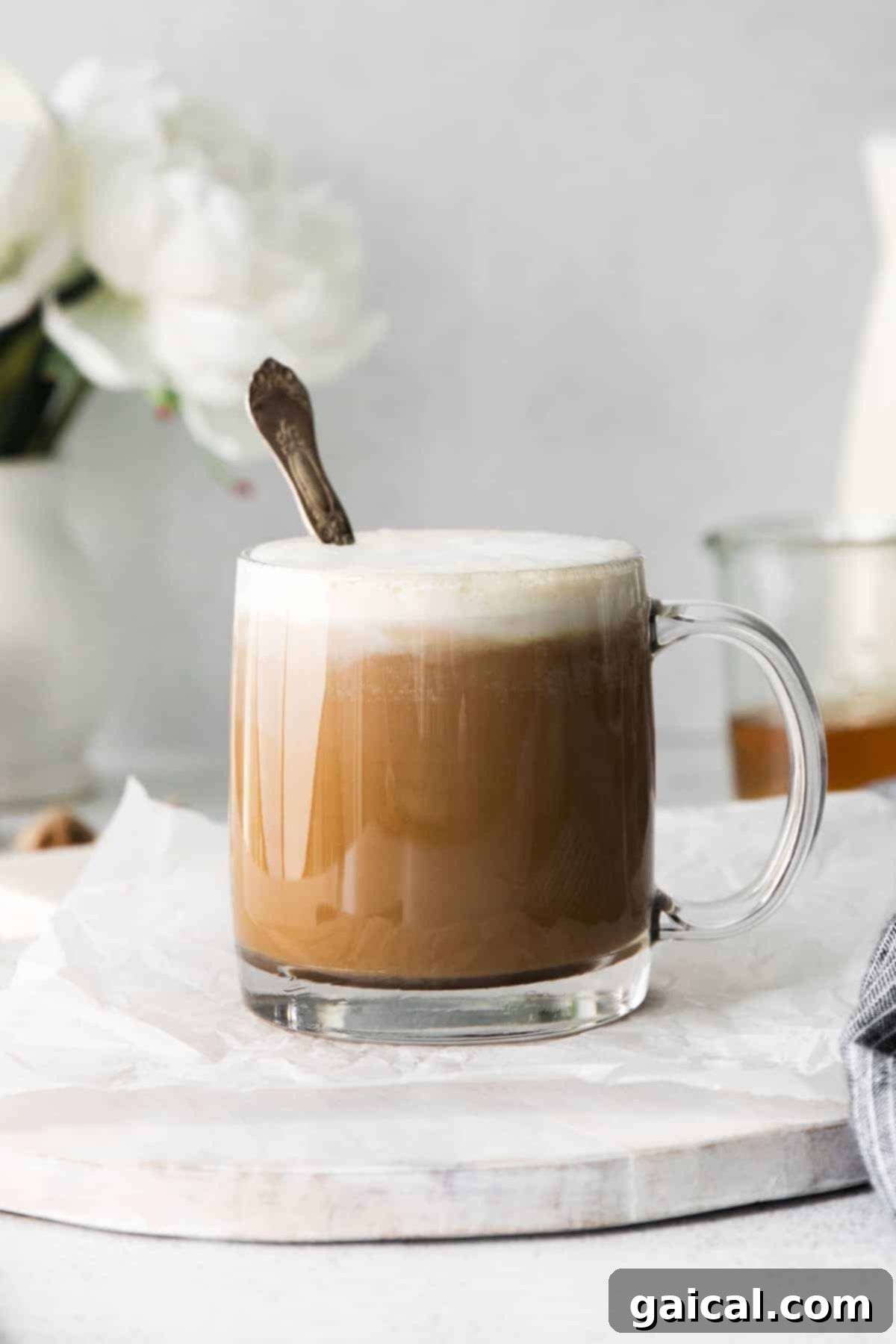 Master the art of making a delightful miel latte at home. A beautifully frothed miel latte in a cozy coffee mug with a spoon, inviting you to take a sip.