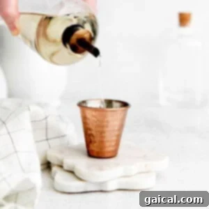 Mastering the Art of Miel Making 2 A small shot glass filled with golden simple syrup, ready for mixing into drinks.