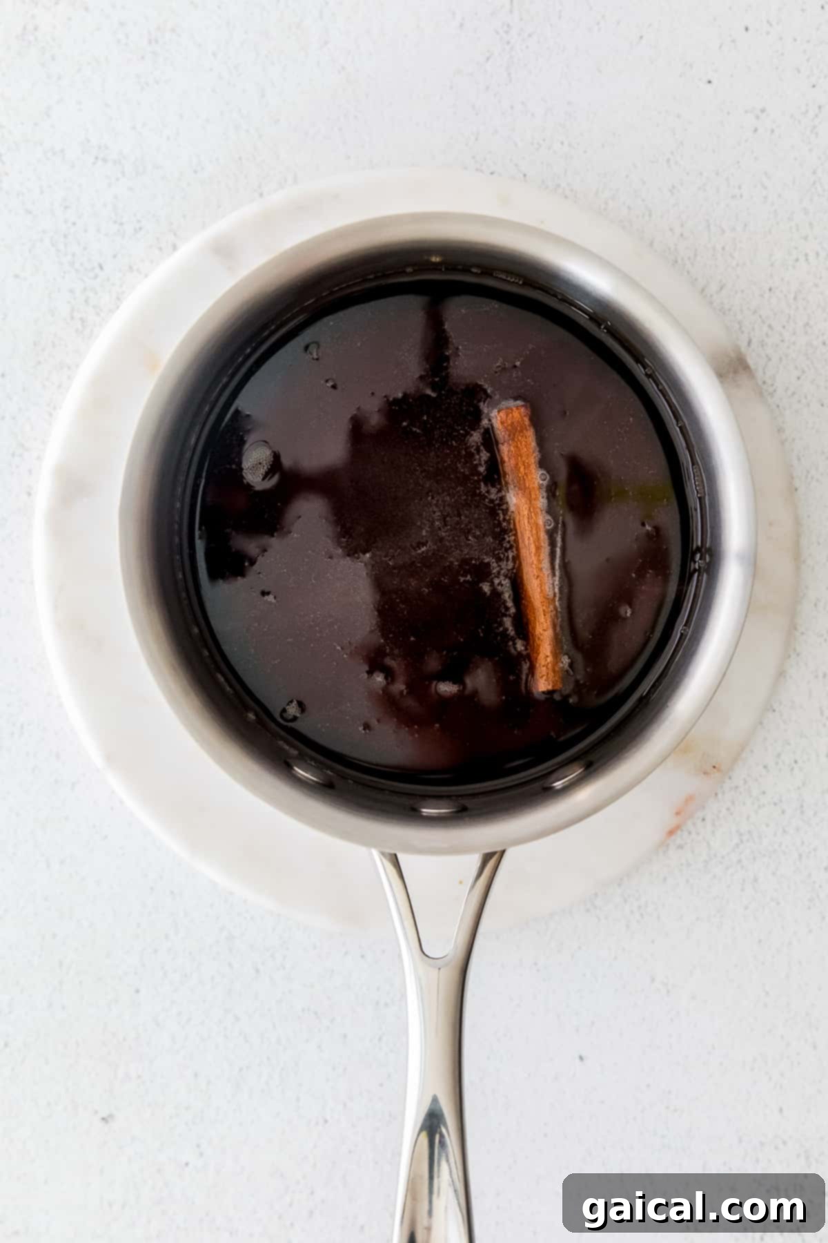 Rich brown sugar simple syrup simmering in a pot on the stovetop, releasing a warm aroma.