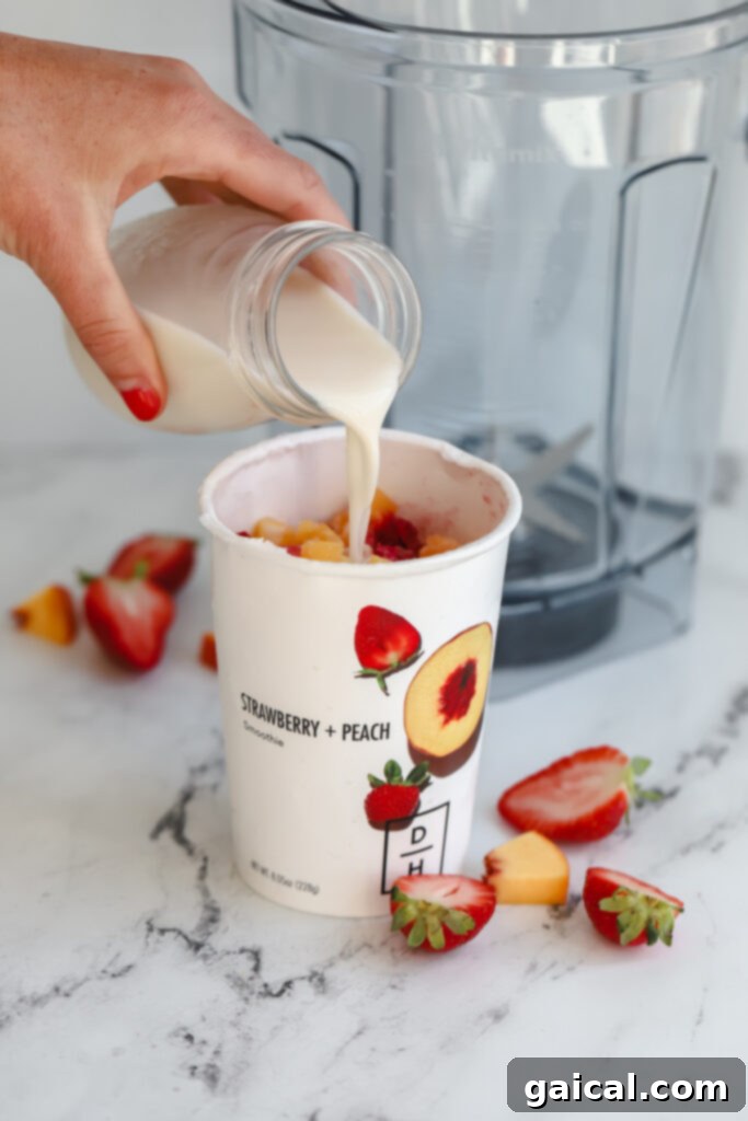 We've been longtime fans of Daily Harvest and their smoothies, so we're thrilled to share our full and honest reviews of ALL of the food in their collections. milk being poured in a smoothie cup before being put in a blender