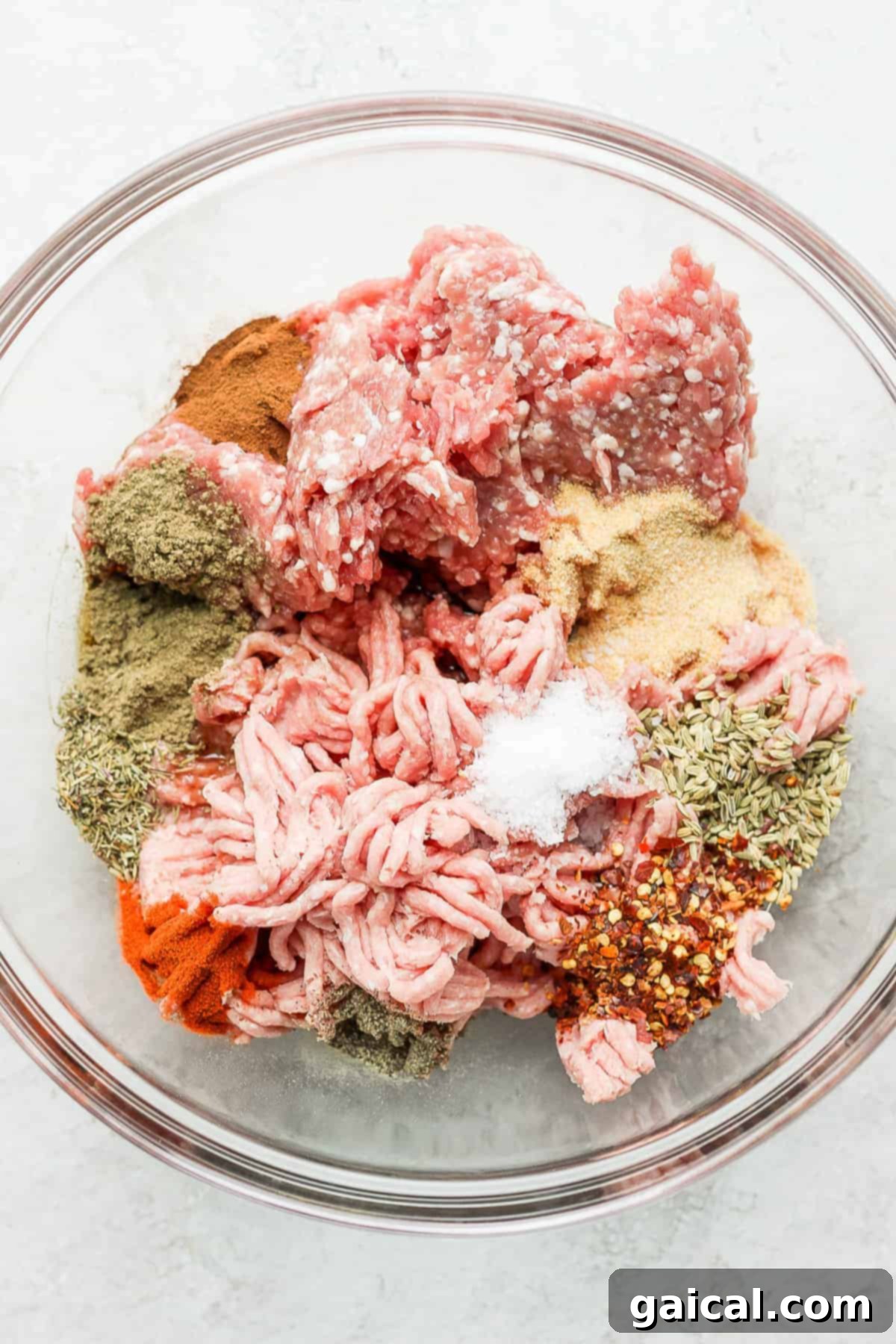 Ground pork and turkey mixed with spices in a bowl, ready to be formed into patties.