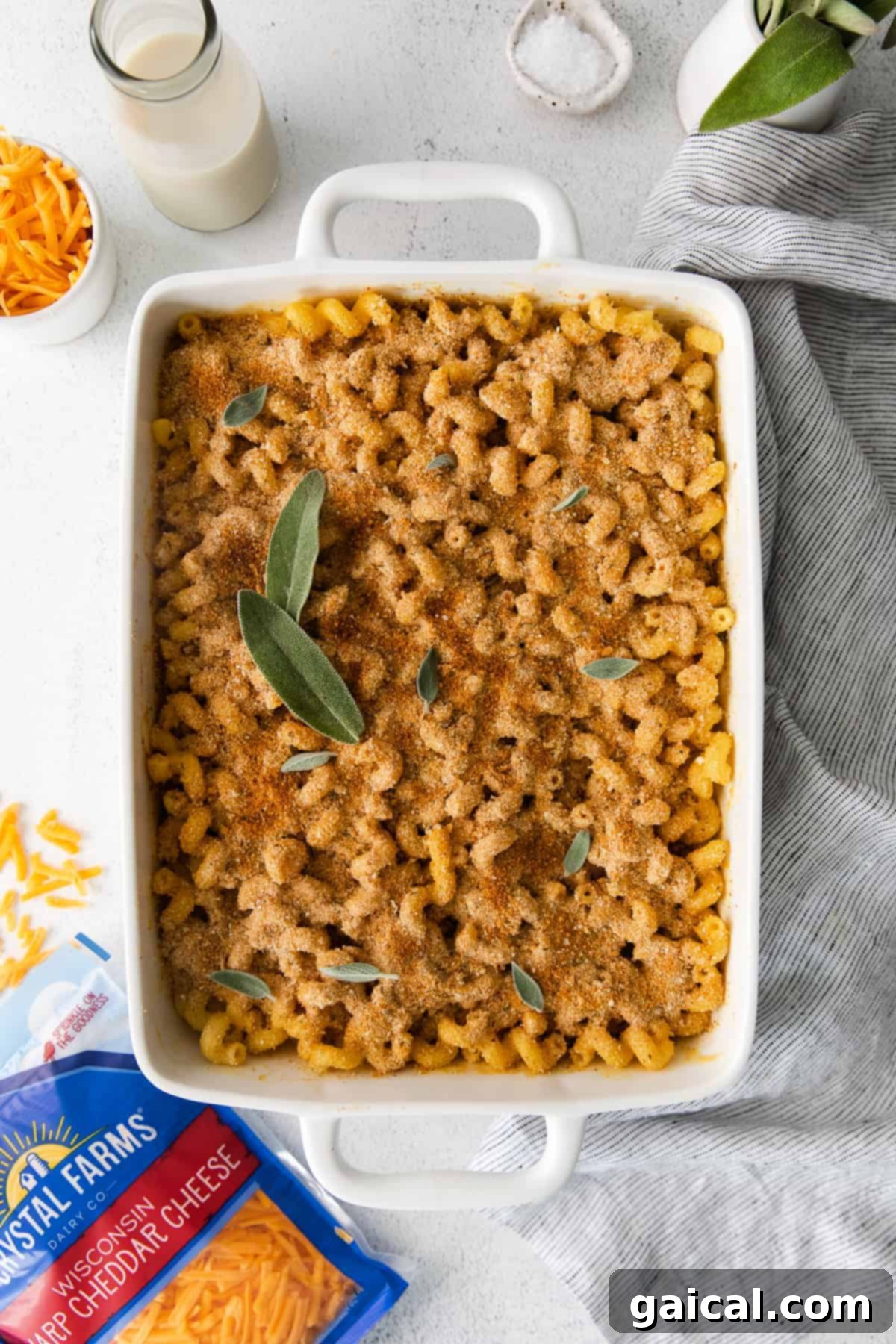 Golden Butternut Mac 2 Butternut squash mac and cheese in a casserole dish topped with fresh sage, ready to serve.