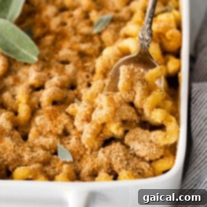 Close-up of baked butternut squash mac and cheese with a golden-brown crust.