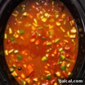 A crock pot full of soup and vegetables.