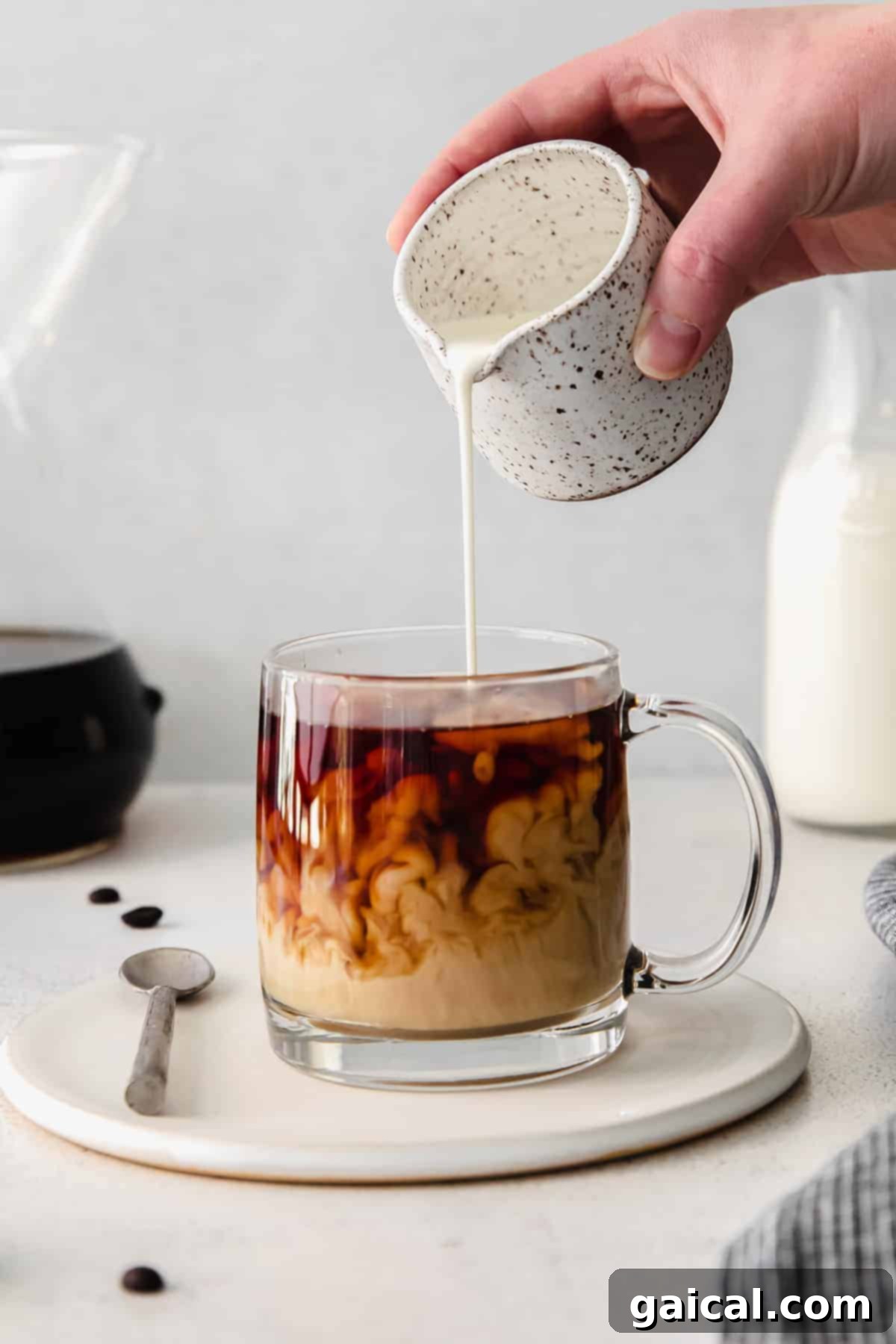 Pour over coffee is hands down the best kind of morning jo. Learn how to use your Chemex in this pour over coffee recipe tutorial. pouring cream into coffee