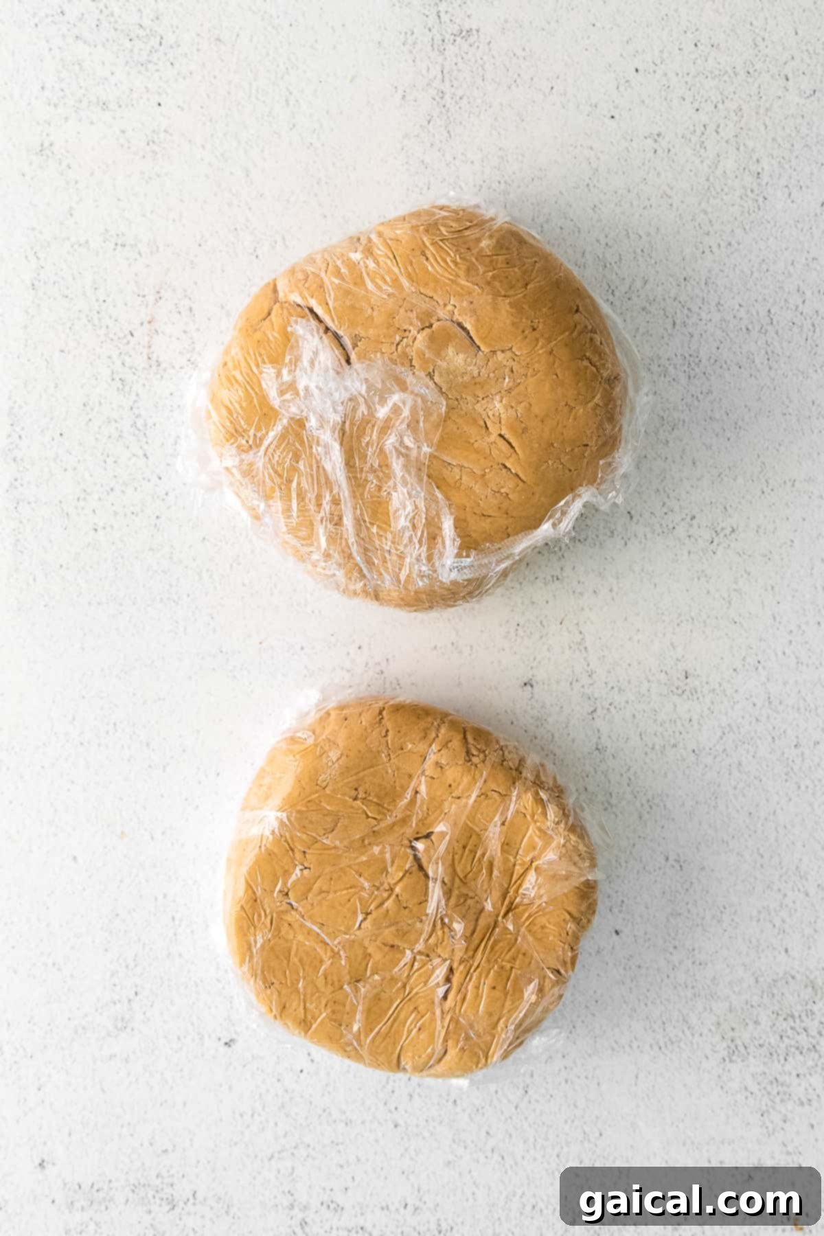 Chilled Cookie Dough Cookie dough discs securely wrapped in plastic wrap, ready for chilling in the refrigerator.