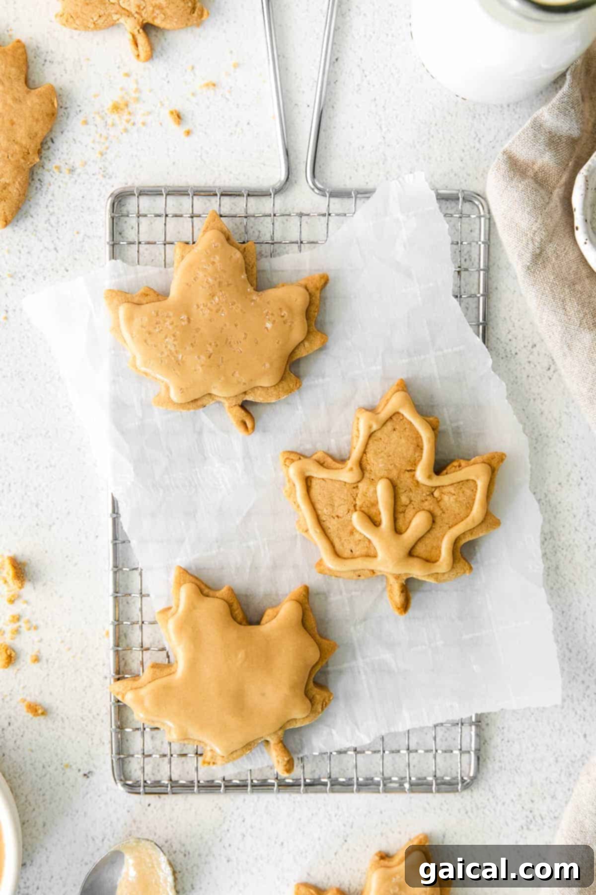 Frosted Maple Sugar Cookies Fully decorated maple sugar cookies artfully arranged on a wire rack, showcasing their delicious frosting.