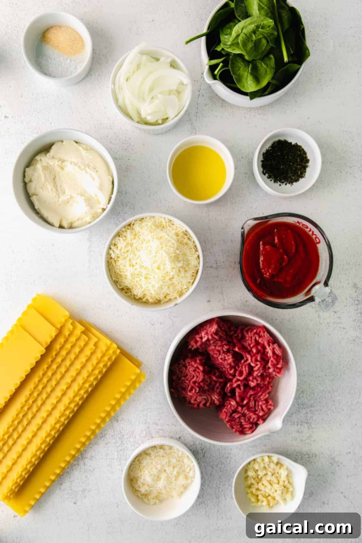 Lasagna Pinwheels 3 All the fresh and essential ingredients for homemade lasagna roll ups artfully arranged on a rustic wooden kitchen counter.