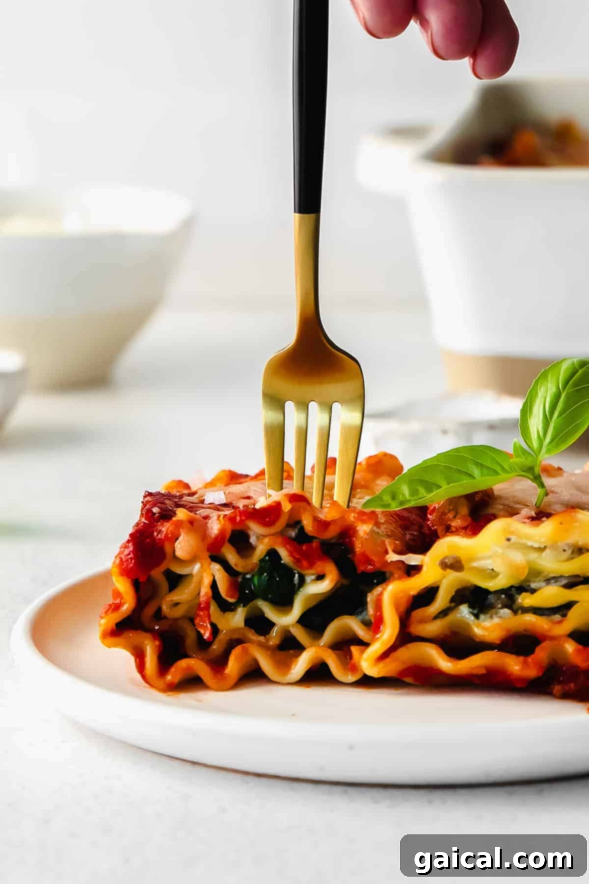 Lasagna Pinwheels 10 Two lasagna roll ups served on a white plate, garnished with fresh basil, ready to be enjoyed, highlighting their individual portion appeal.