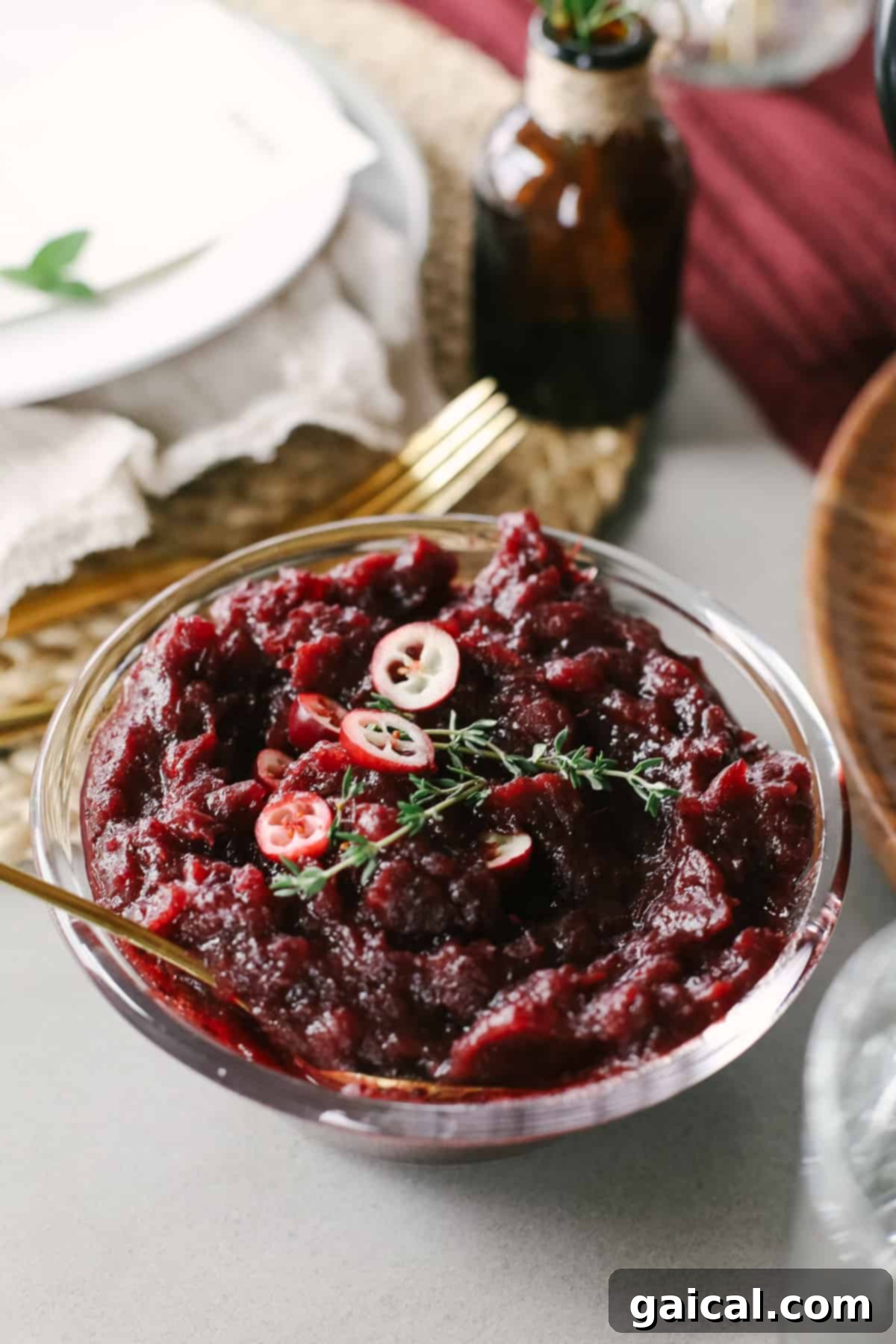 A bowl of vibrant homemade lemon ginger cranberry sauce, garnished with fresh cranberries and lemon zest.