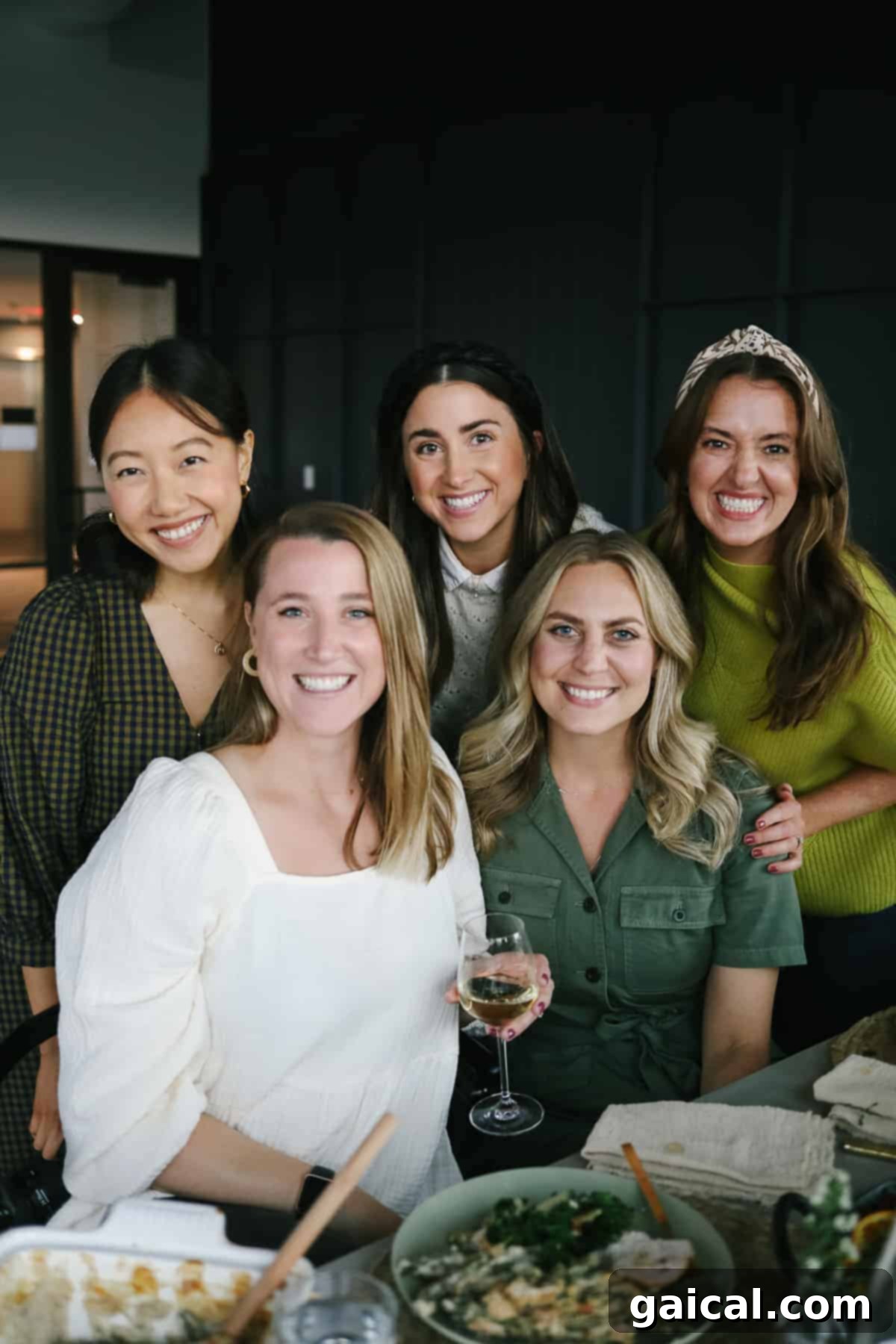 Five women gathered around a beautifully adorned Thanksgiving table, sharing laughter and enjoying the holiday feast.